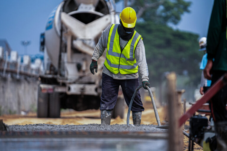 A,Construction,Worker,Pouring,A,Wet,Concret,At,Road,Construction
